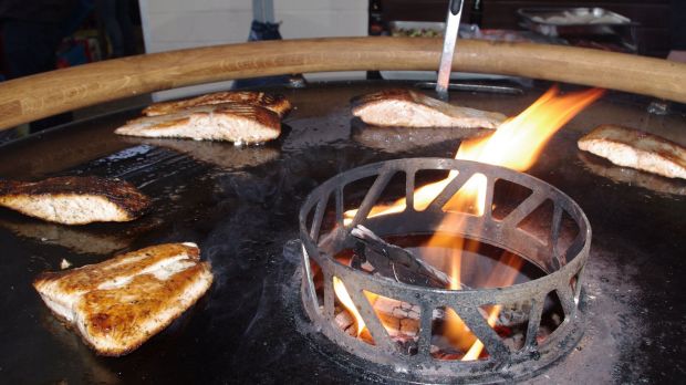 Kurzbratartikel wie Lachs und Steaks wurden auf der Platte der Feuertonne gegrillt. Kurzbratartikel wie Lachs und Steaks wurden auf der Platte der Feuertonne gegrillt.