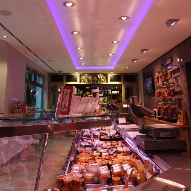 An der Decke zieht das Lichtband der Vouteninstallation die gewinkelte Form der Theke nach. An der Decke zieht das Lichtband der Vouteninstallation die gewinkelte Form der Theke nach.