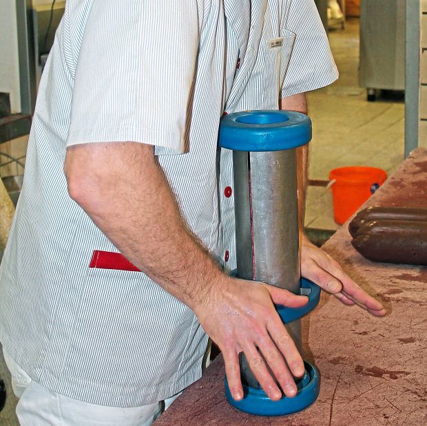 Mit gleichmäßigem, aber kraftvollem Druck werden die Würste in drei gleiche Portionen geschnitten. Mit gleichmäßigem, aber kraftvollem Druck werden die Würste in drei gleiche Portionen geschnitten.